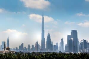 Dubai downtown skyline with Burj Khalifa rising above modern towers and a mosque minaret in the foreground