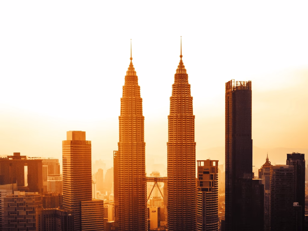 Kuala Lumpur downtown skyline with the Petronas Twin Towers glowing at sunset